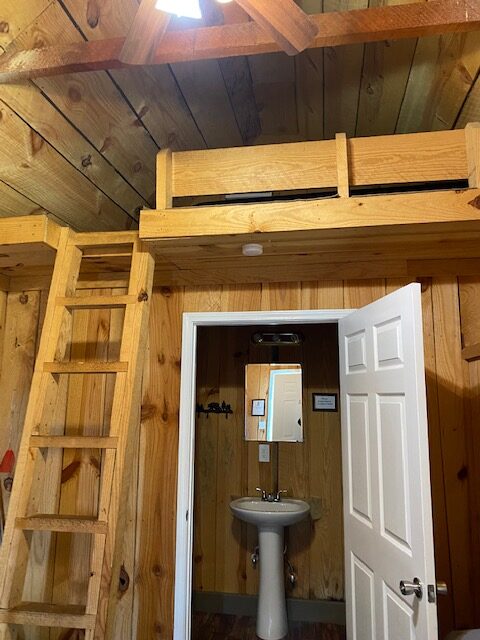 6 person cabin interior with ladder to loft area, ceiling fan, bathroom