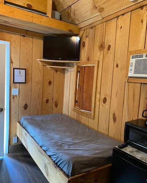 6 person cabin interior with bed, TV, window, microwave, space heater