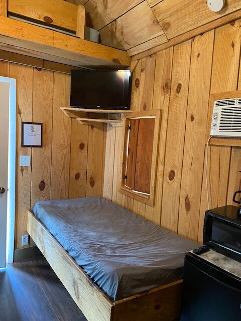6 person cabin interior with bed, TV, window, microwave, space heater