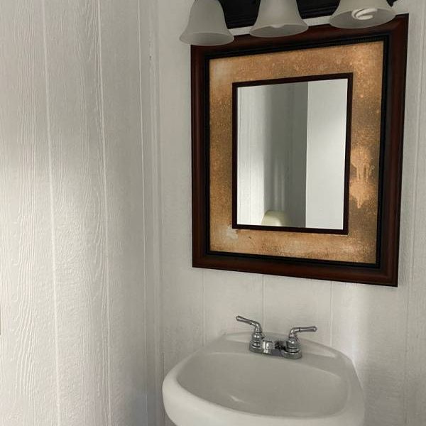 Boo Boo cabin interior bathroom with sink, mirror, lighting
