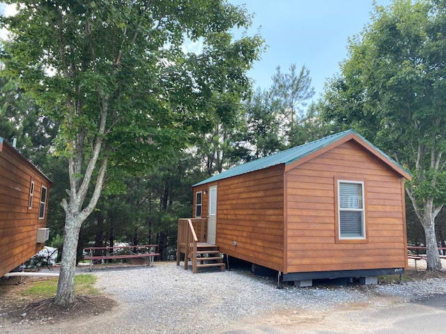 Ranger Smith cabin exterior with gravel walkway, picnic table, and trees